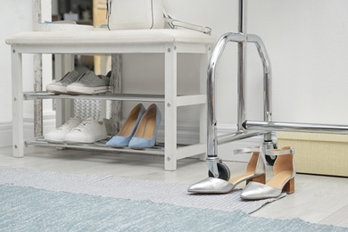 Photo of Stylish hallway interior with storage bench near light wall