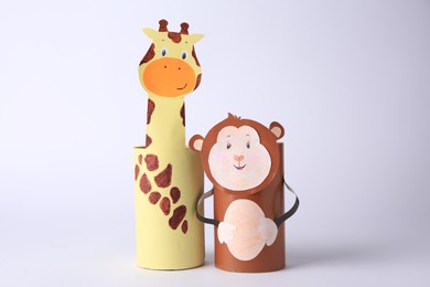 Photo of Toy monkey and giraffe made from toilet paper hubs on white background. Children's handmade ideas