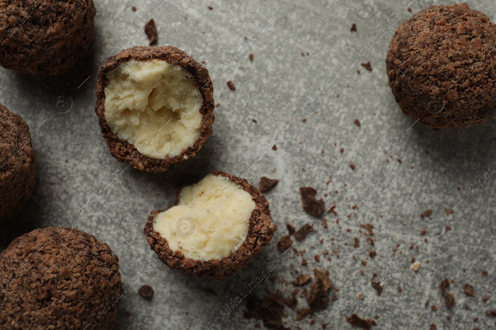 Photo of Many delicious chocolate truffles on grey table, flat lay