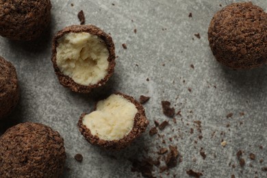 Many delicious chocolate truffles on grey table, flat lay