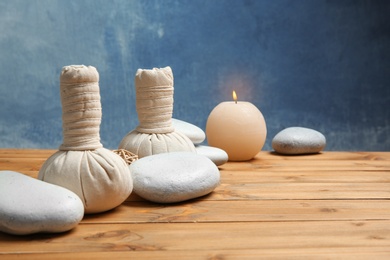 Photo of Beautiful composition with spa stones on wooden table. Space for text