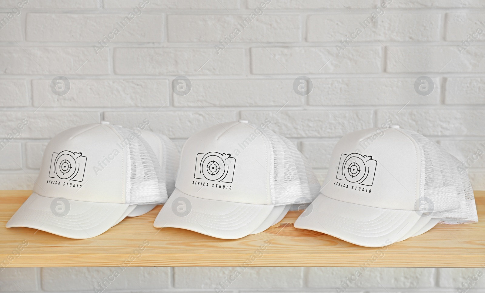 Photo of White caps with logo on wooden shelf in shop