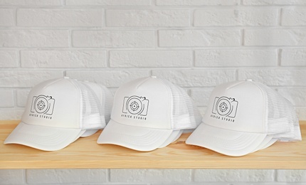 White caps with logo on wooden shelf in shop