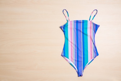 Photo of Beautiful swimsuit on wooden background, top view