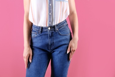 Photo of Woman in stylish blue jeans on color background