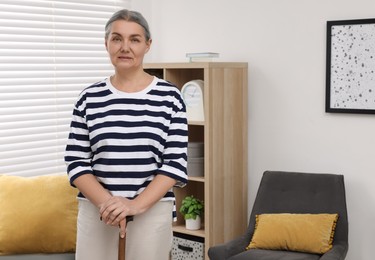 Photo of Senior woman with walking cane at home