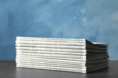 Photo of Stack of newspapers on blue background. Journalist's work