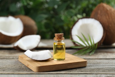 Photo of Bottle of organic coconut cooking oil on wooden table