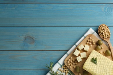 Photo of Cut tofu, olives and soya beans on blue wooden table, flat lay. Space for text