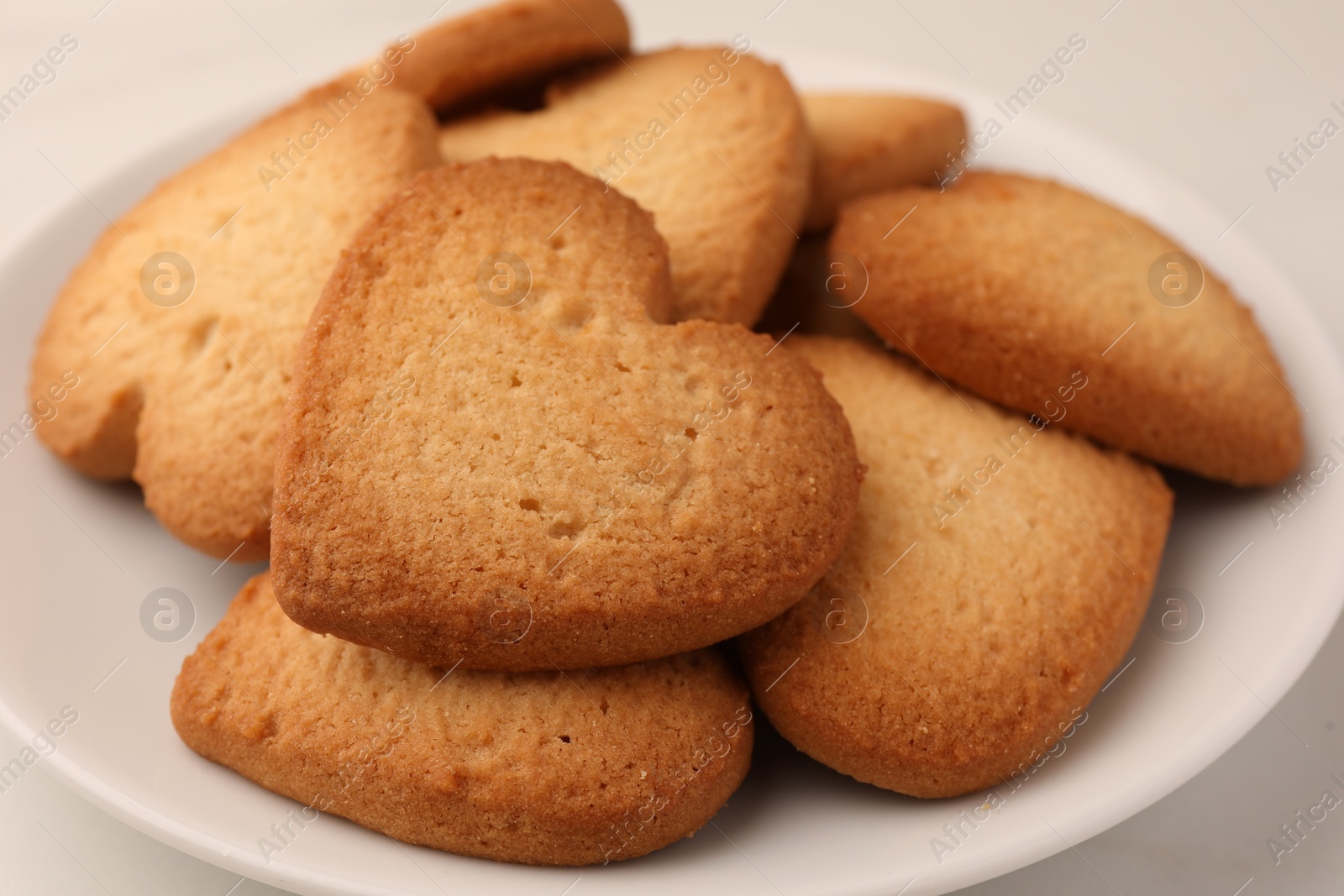 Photo of Heart shaped Danish butter cookies on plate, closeup