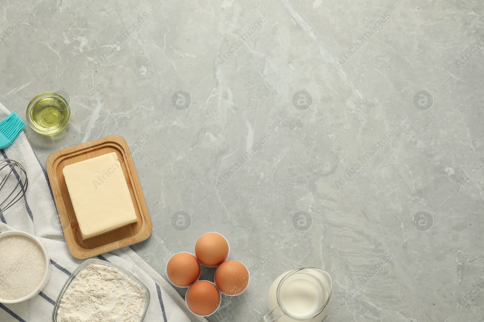 Photo of Flat lay composition with fresh butter and other products on grey marble table. Space for text