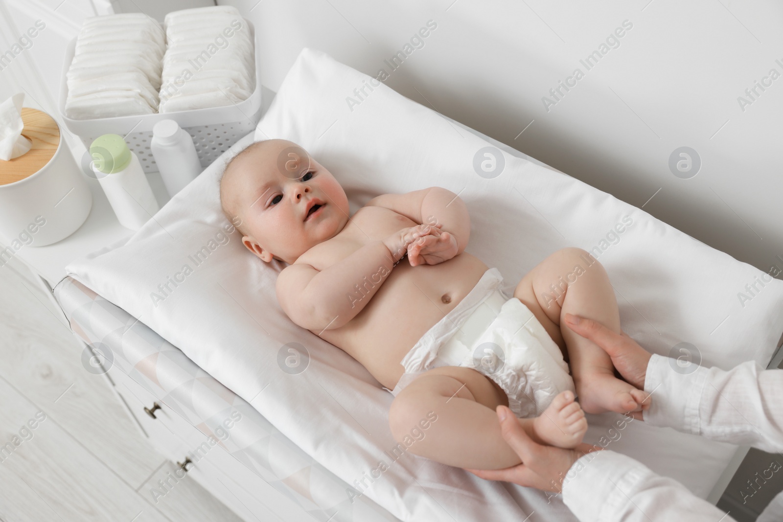 Photo of Mother with her baby at changing table indoors, closeup