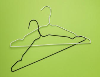 Empty clothes hangers on green background, flat lay