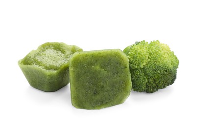 Photo of Frozen broccoli puree cubes and fresh broccoli isolated on white