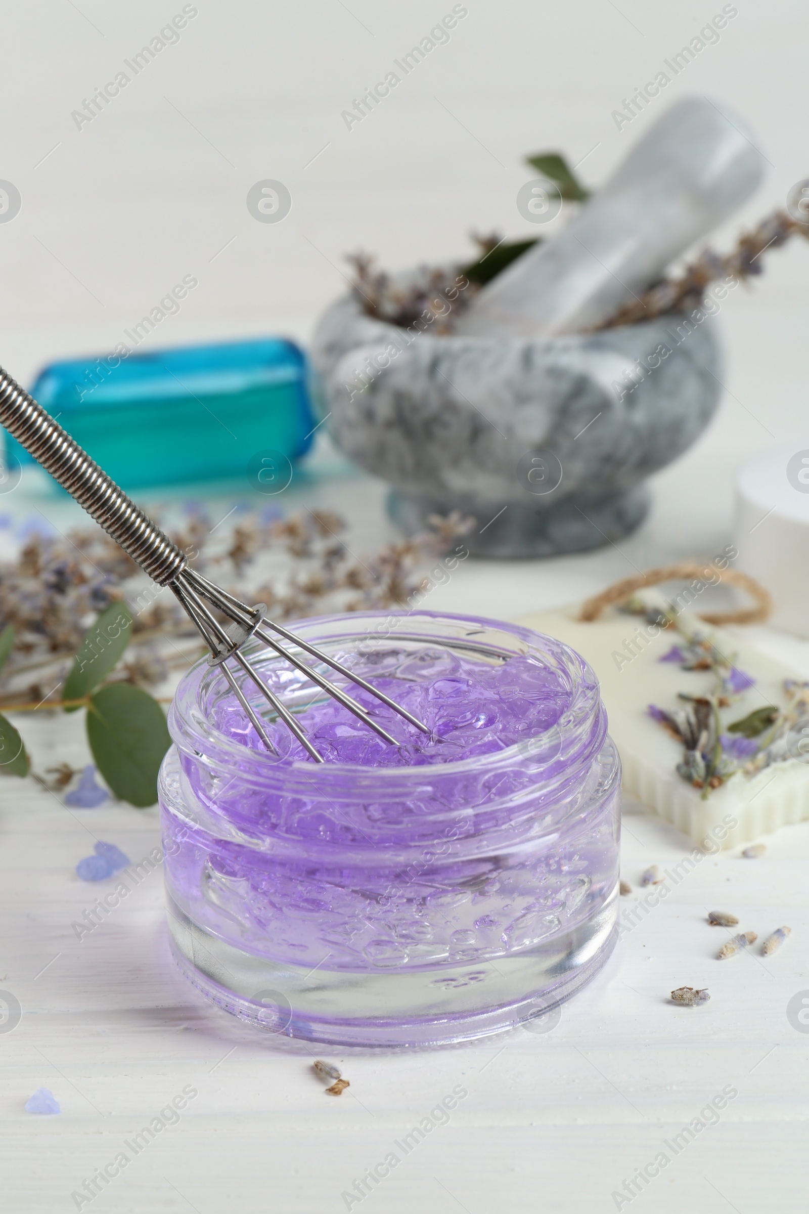 Photo of Homemade lavender gel and whisk on white wooden table