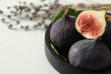 Whole and cut tasty fresh figs on white table, closeup. Space for text