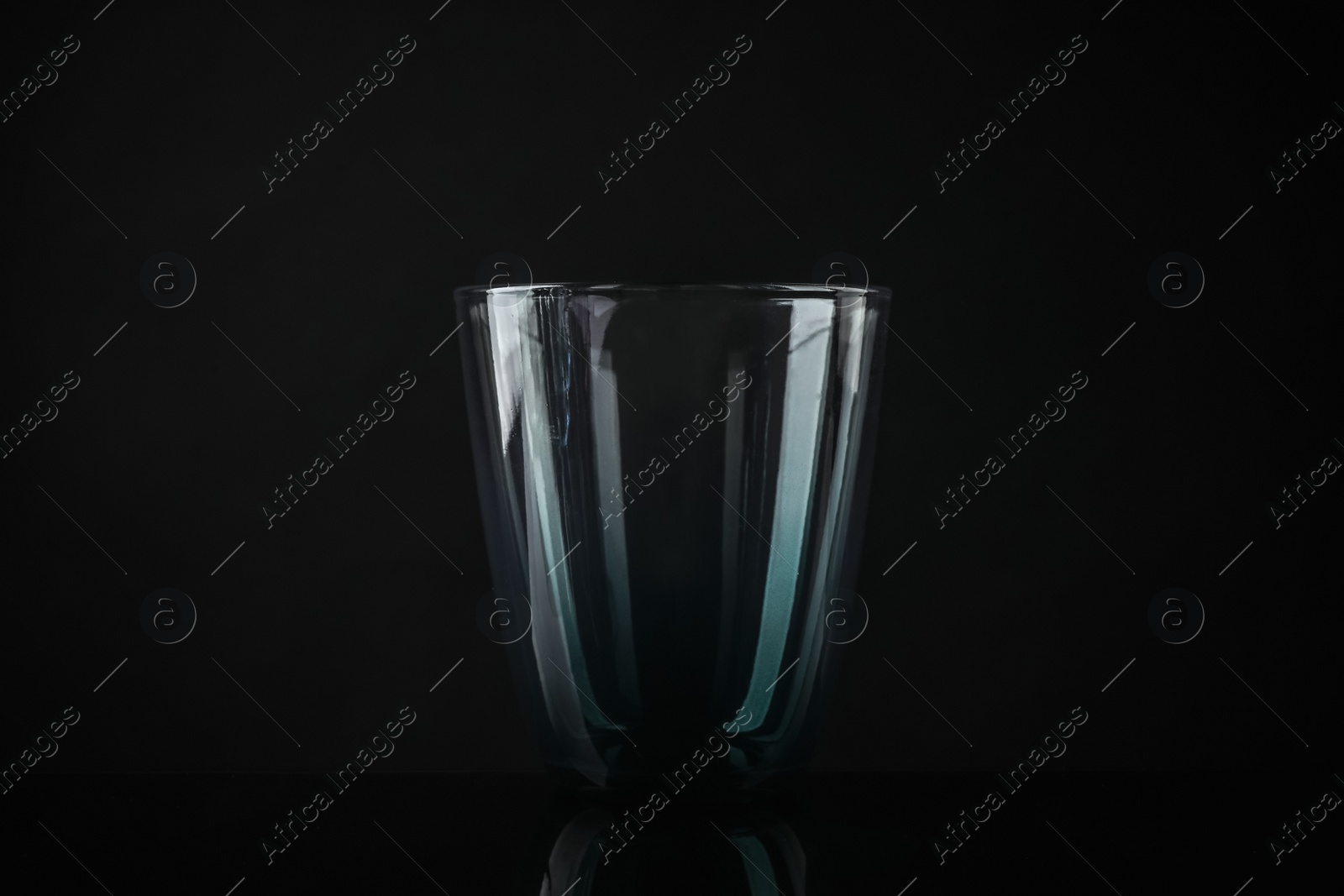 Photo of Elegant empty colorful glass on black background