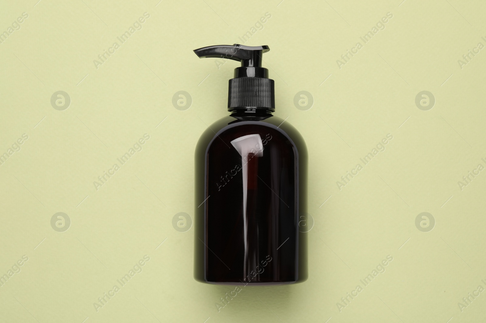 Photo of Bottle of shampoo on light green background, top view