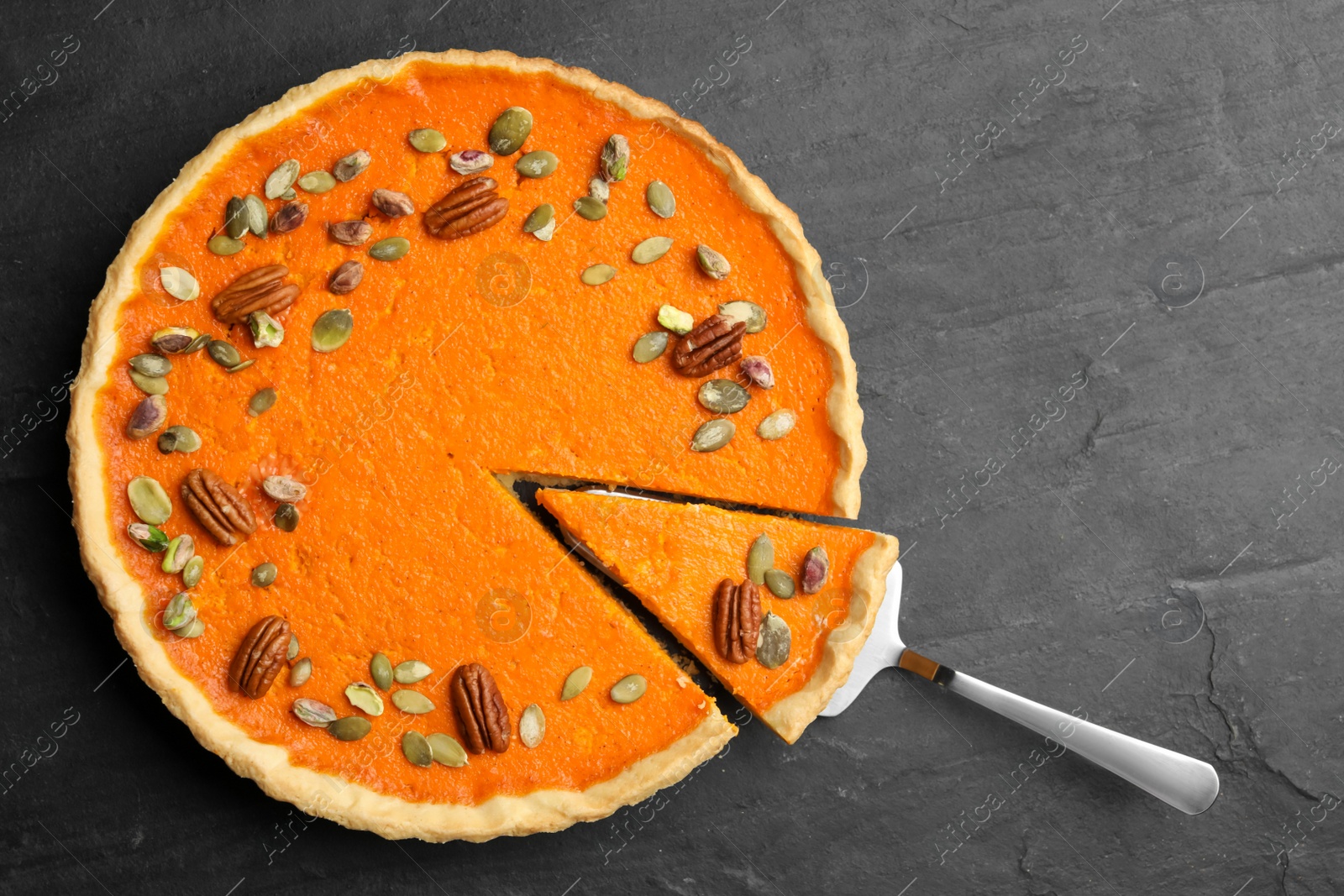 Photo of Delicious homemade pumpkin pie on black table, top view