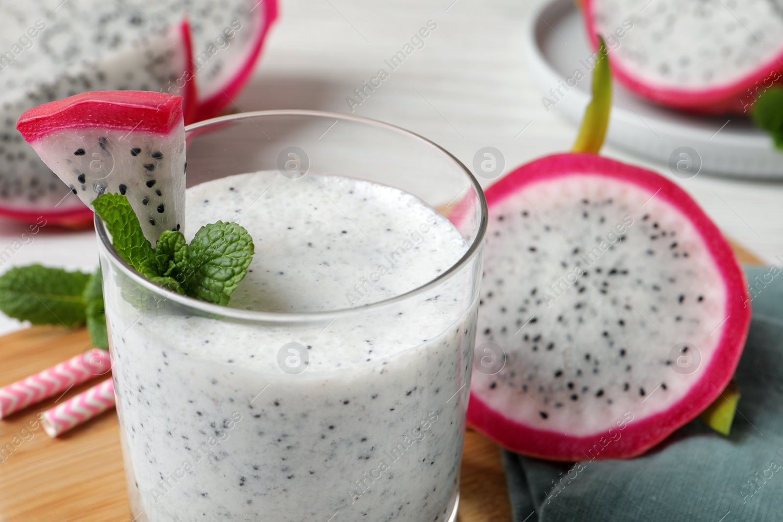 Photo of Glass of tasty pitahaya smoothie with fresh mint on table, closeup. Space for text