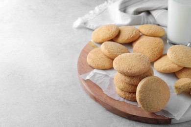 Many tasty sugar cookies on light grey table, space for text