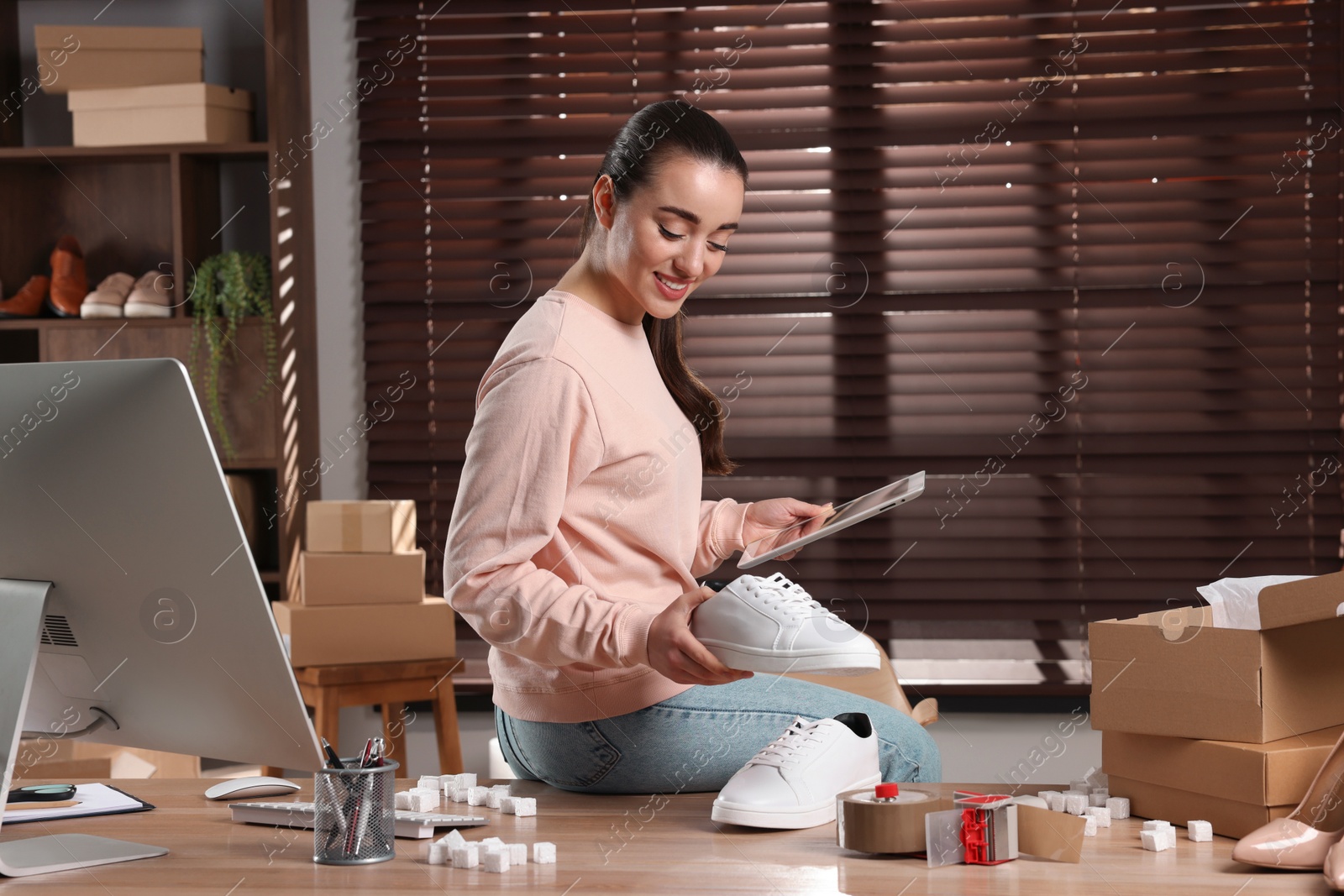 Photo of Shoes seller working with tablet in office. Online store