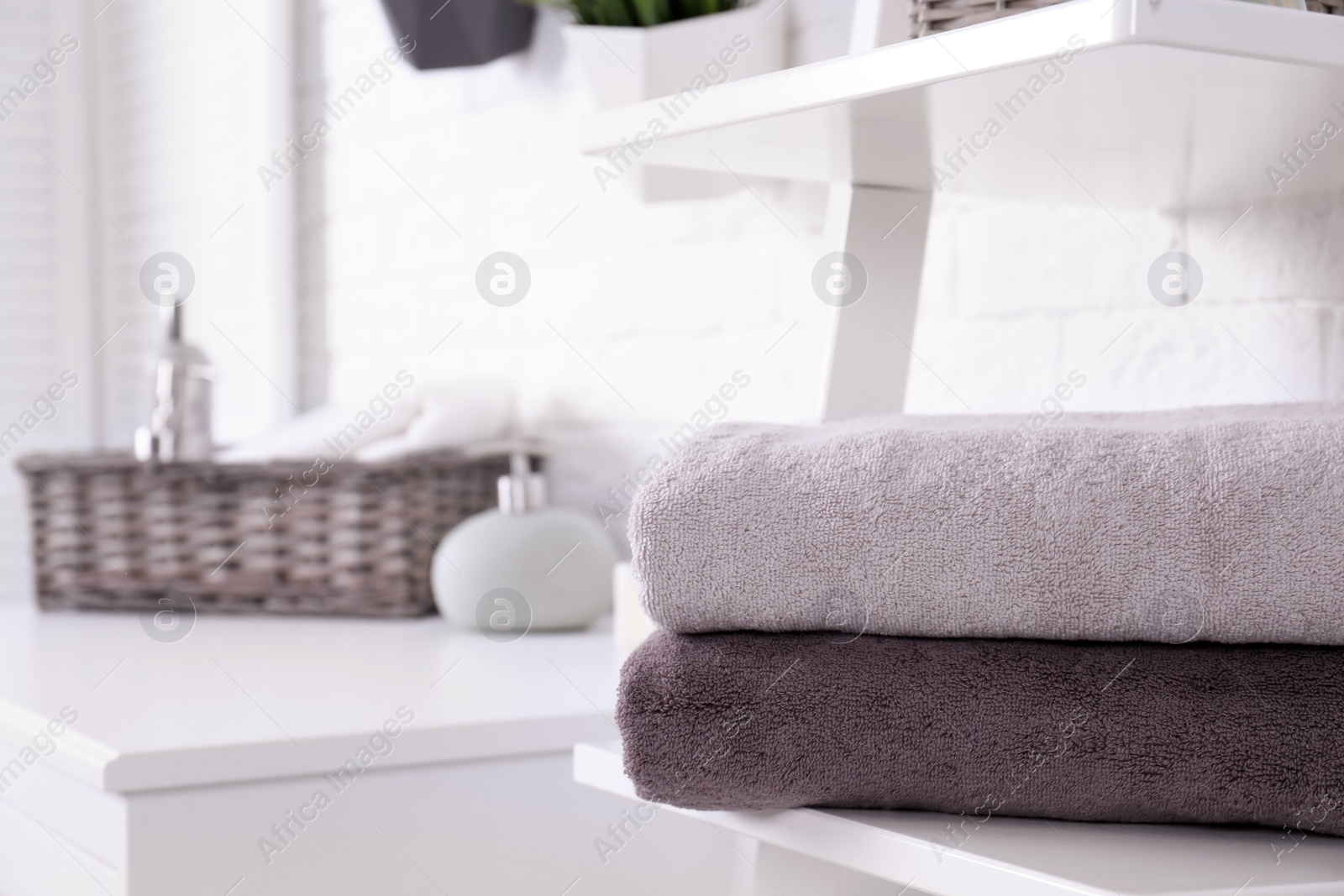 Photo of Stack of fresh towels on shelf in bathroom. Space for text