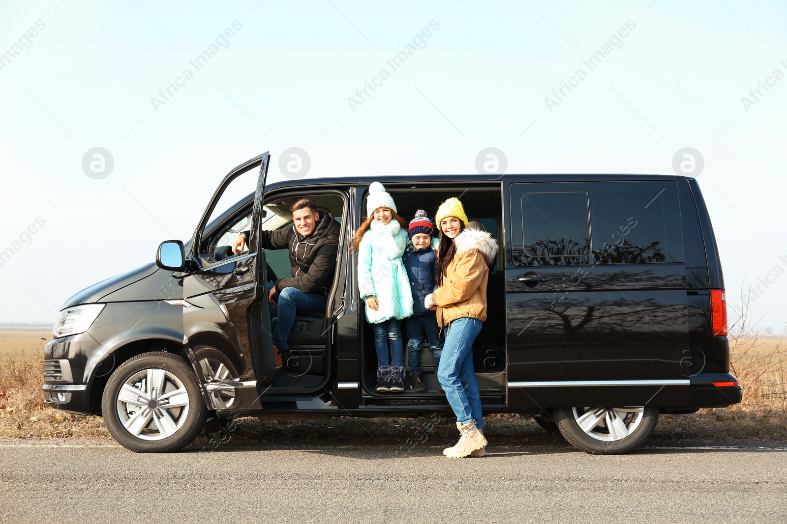 Photo of Happy family with little children in modern car on road