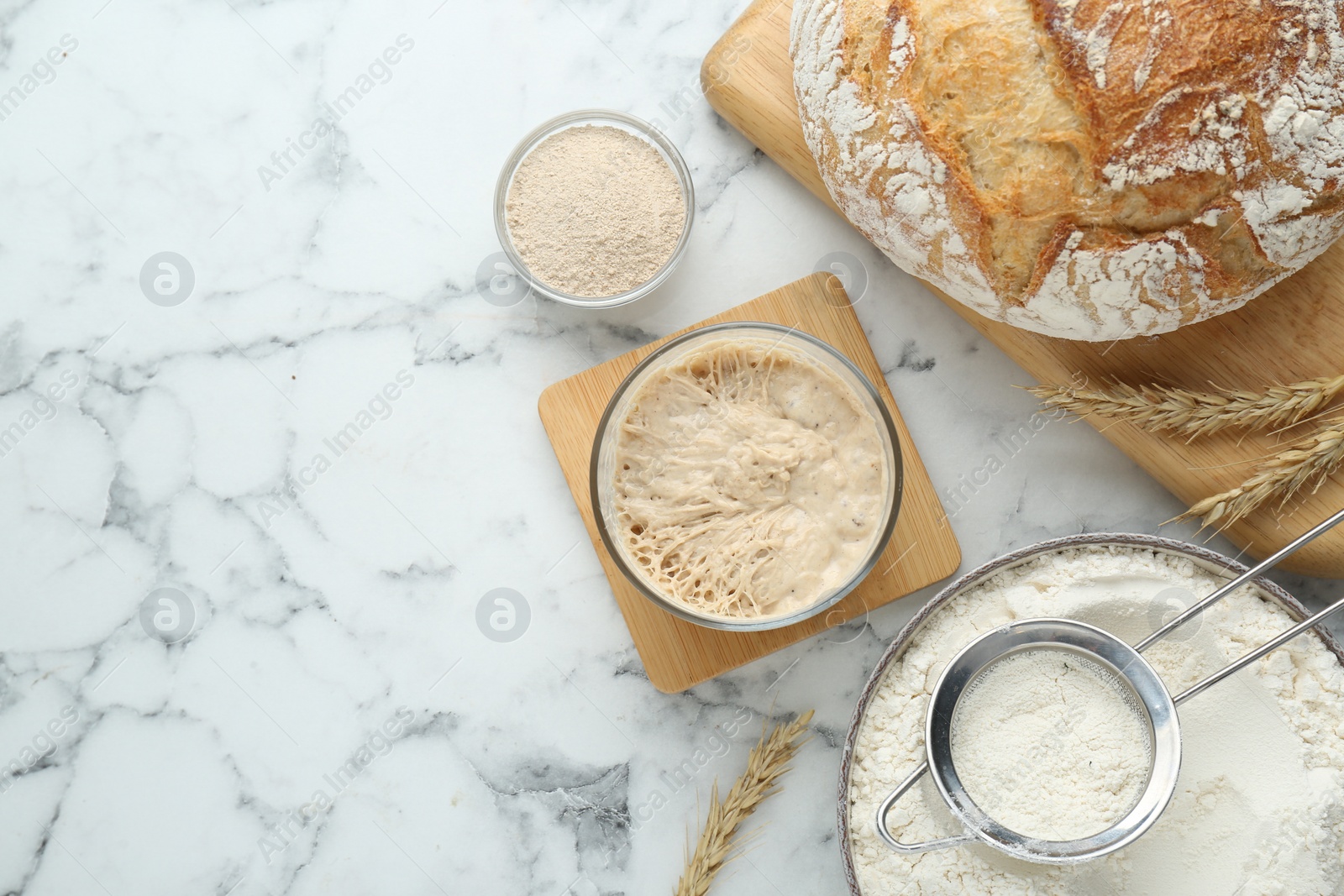 Photo of Flat lay composition with sourdough on white marble table. Space for text