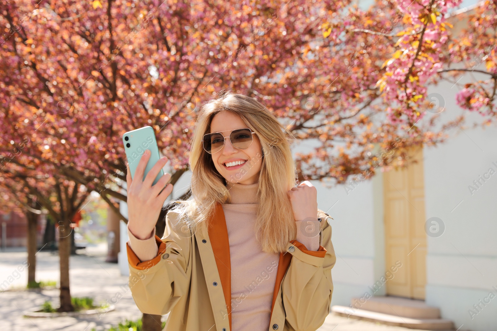 Photo of Young woman taking selfie on city street