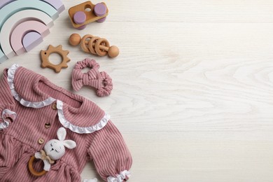 Flat lay composition with baby clothes and accessories on white wooden background, space for text