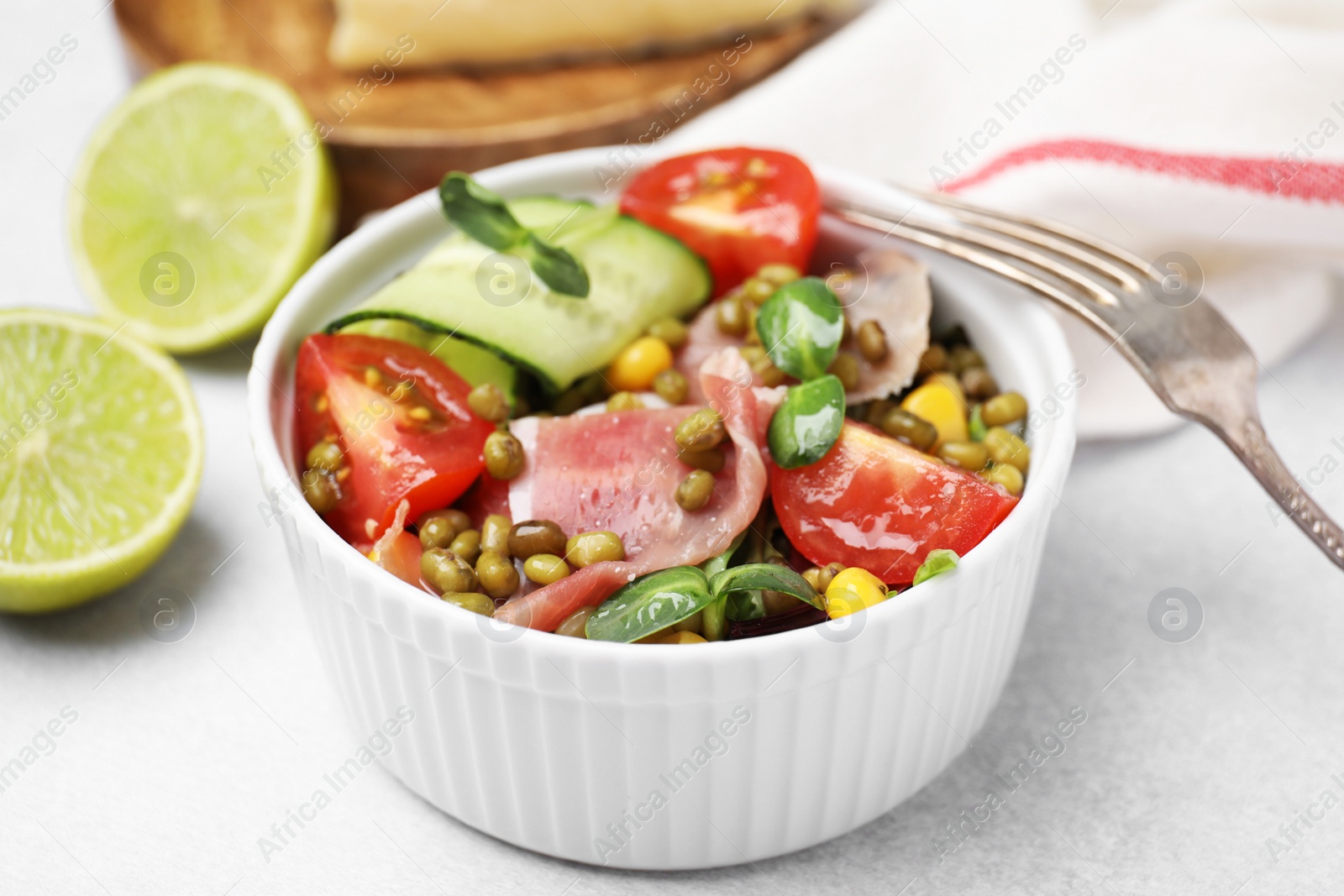 Photo of Bowl of salad with mung beans on white table, closeup