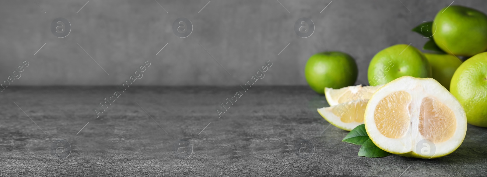 Image of Cut and whole fresh sweeties on grey table, space for text. Banner design