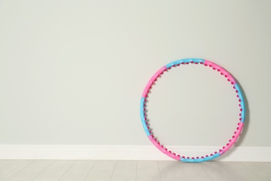 Photo of Hula hoop near light wall in gym. Space for text