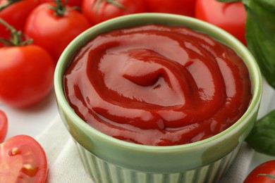 Photo of Bowl of tasty ketchup, tomatoes and basil on white table, closeup