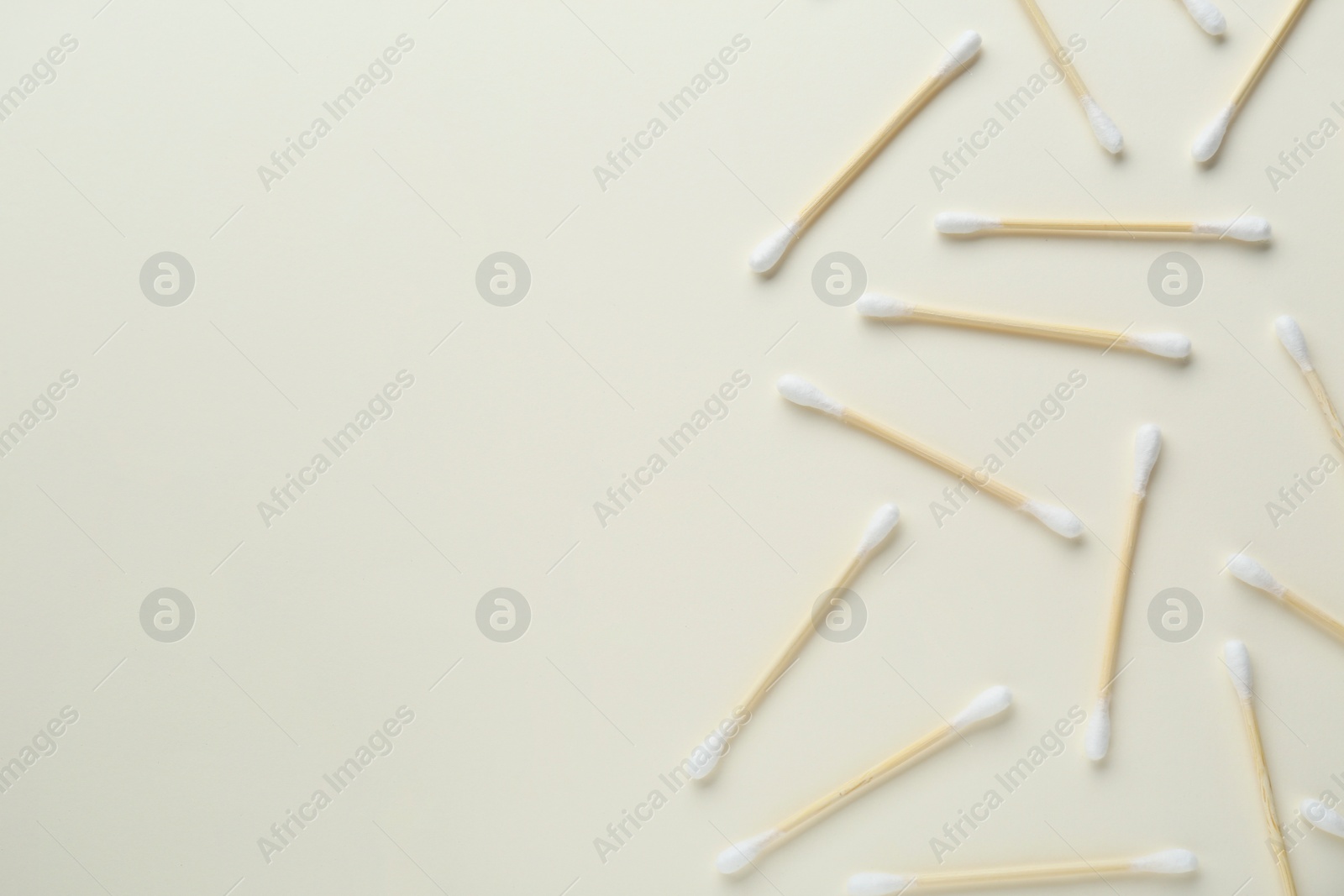 Photo of Many wooden cotton buds on beige background, flat lay. Space for text