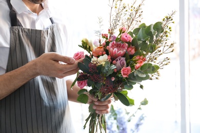 Male florist creating beautiful bouquet, closeup