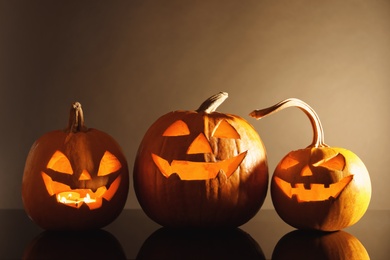 Photo of Halloween pumpkin heads. Glowing jack lanterns on dark background