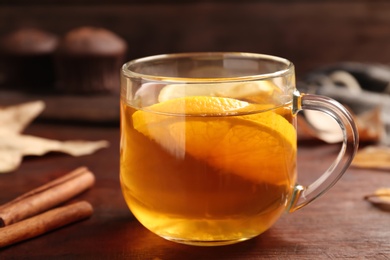 Photo of Cup of tasty tea with lemon on wooden table, closeup