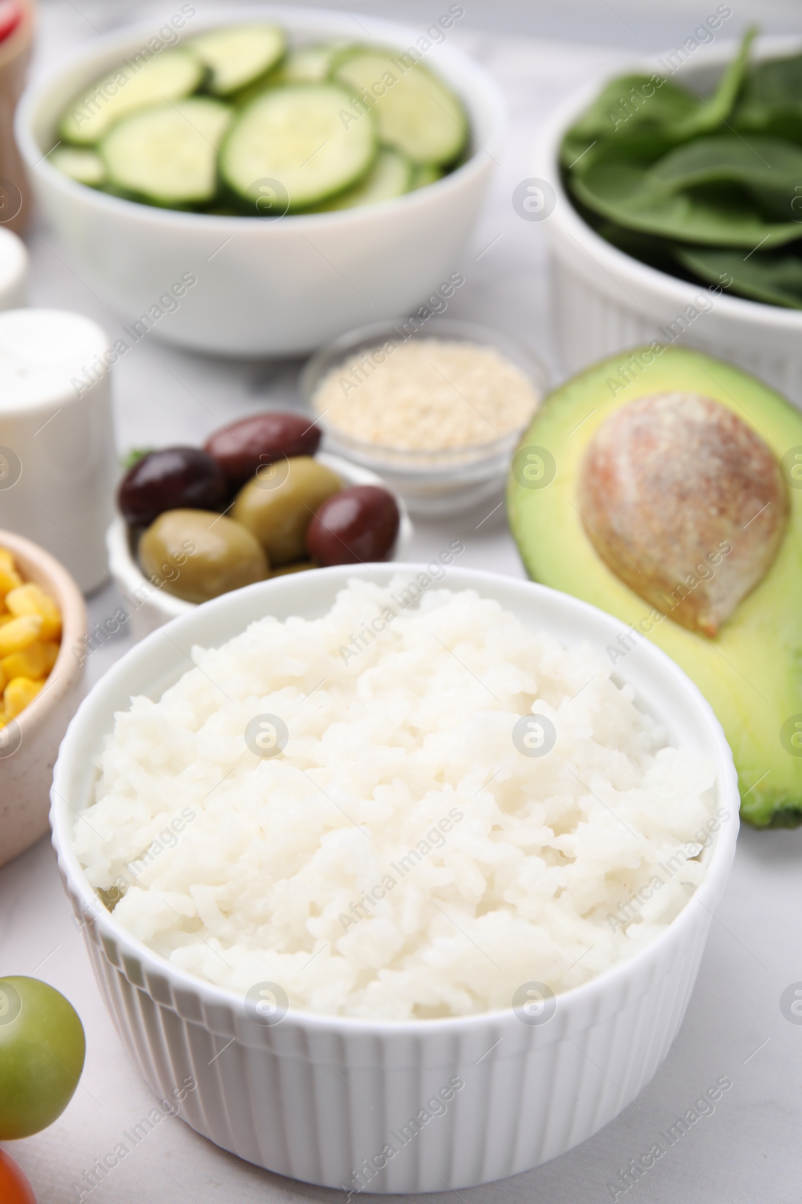 Photo of Ingredients for poke bowl on white marble table, closeup