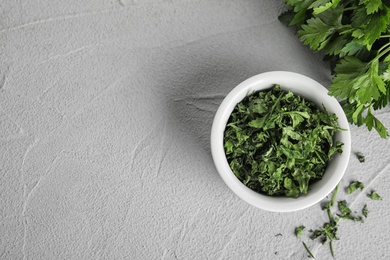 Photo of Flat lay composition with fresh and dried parsley on grey stone table. Space for text
