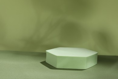 Photo of Presentation of product. Podium and shadows on light green background. Space for text