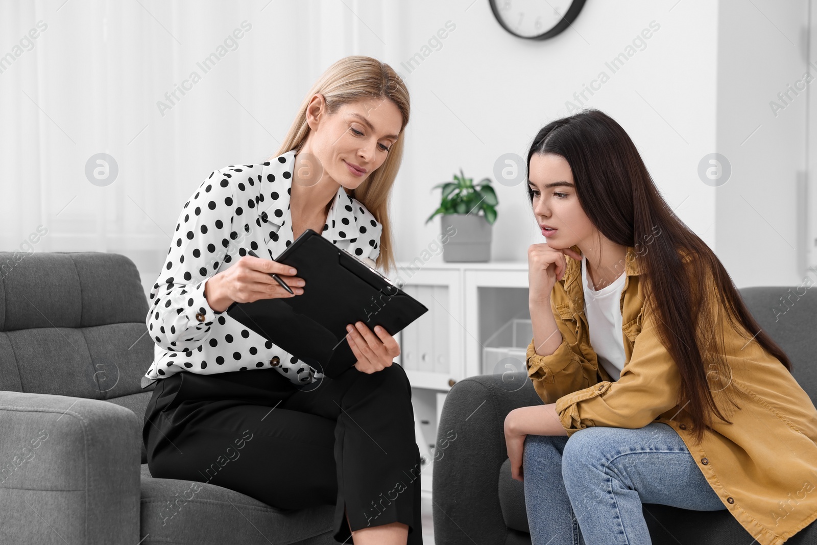 Photo of Psychologist working with teenage girl in office