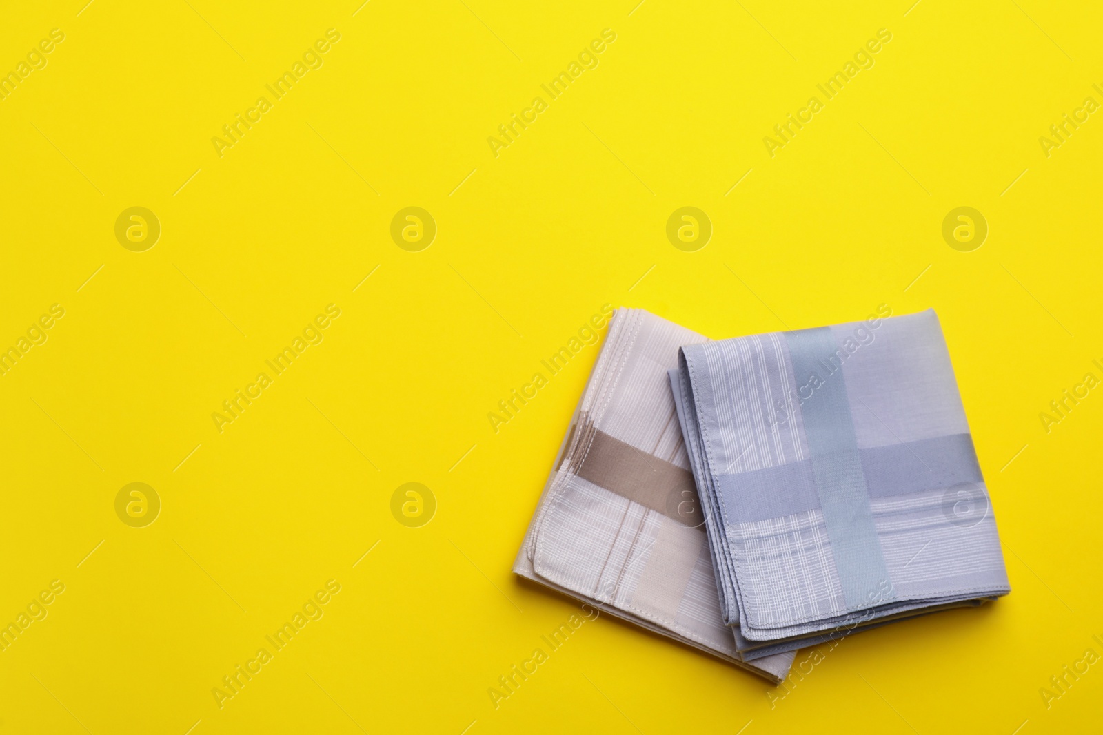 Photo of Stylish handkerchiefs on yellow background, flat lay. Space for text