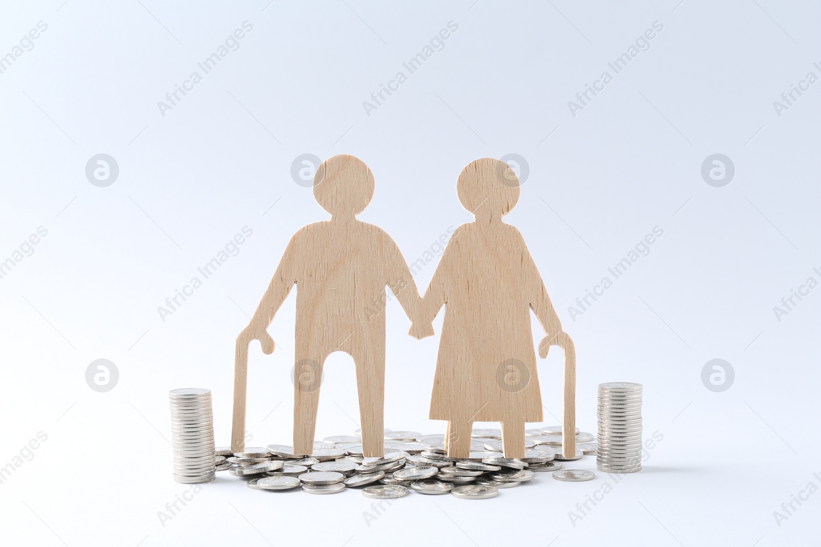 Photo of Pension savings. Figure of senior couple and coins on white background