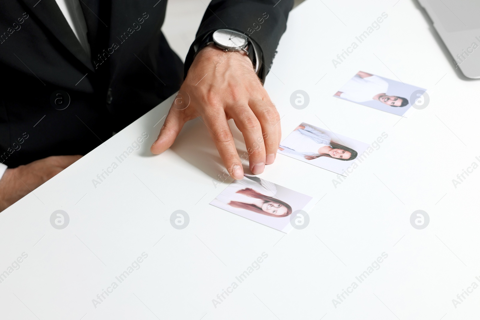 Photo of Human resources manager choosing employee among different applicants at table, closeup