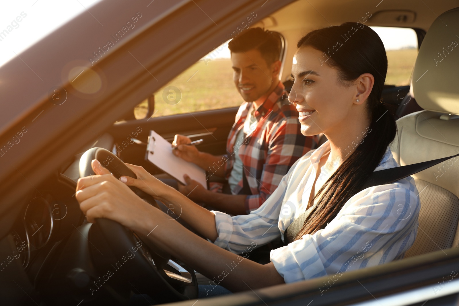 Photo of Young woman in car with instructor. Driving school