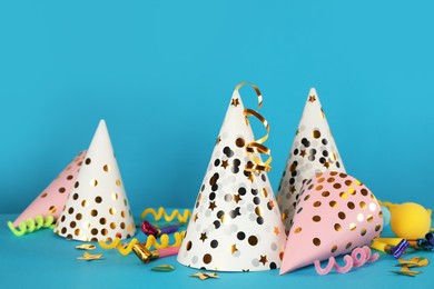 Photo of Many party hats and festive items on light blue background