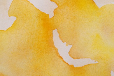 Photo of Abstract orange watercolor painting on white paper, top view