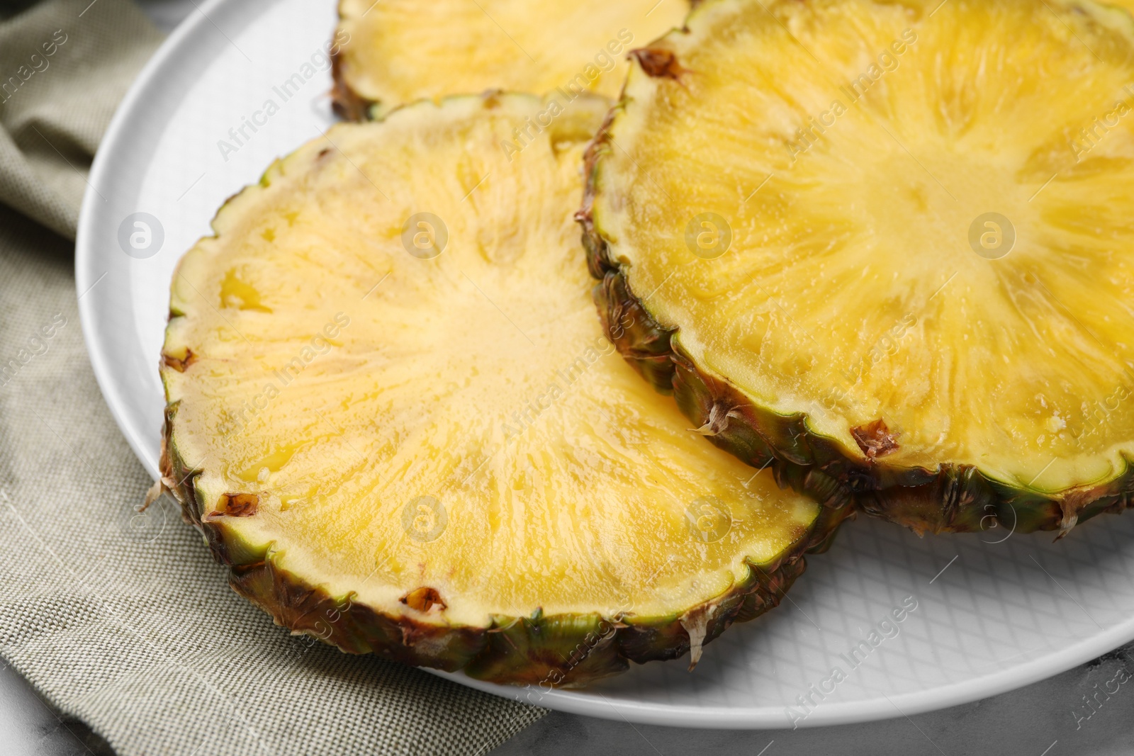 Photo of Slices of tasty ripe pineapple on table, closeup